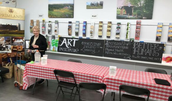 Woman at red checkered table in front of arts and crafts display