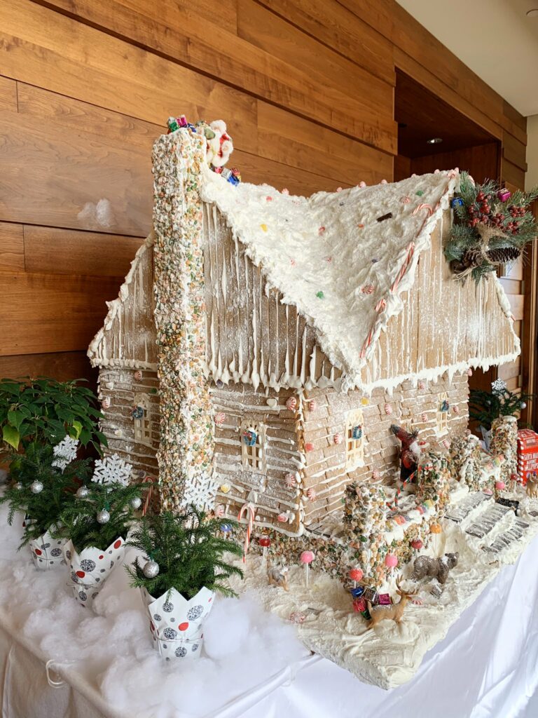 Gingerbread house surrounded by tiny Christmas trees