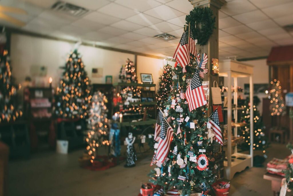 Christmas trees in a store with American flags and white lights
